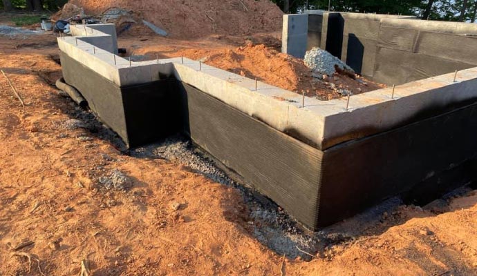 Building foundation and walls covered in waterproofing material
