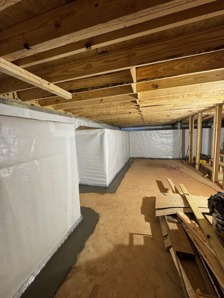 Basement walls lined with DryWorx's white wall waterproofing panel system