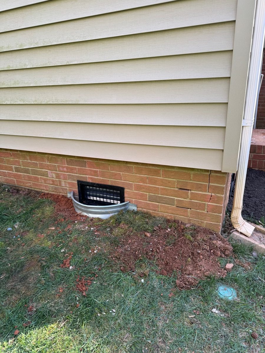 A brick-foundation crawl space vent — the passive ventilation a sealed crawl space replaces