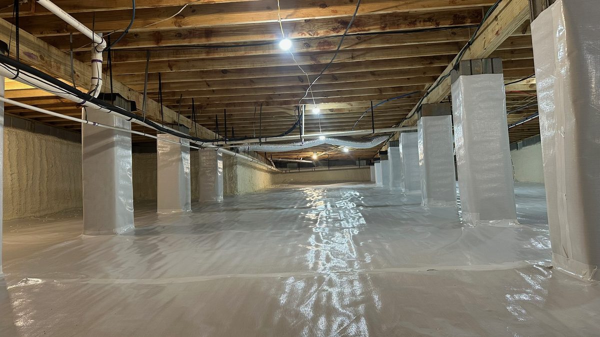 Finished crawl space encapsulation with a white vapor barrier and sealed support columns