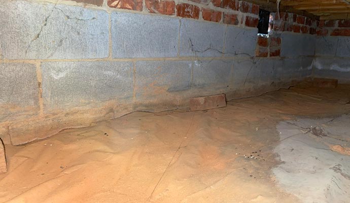 A dirt crawl space covered with a vapor barrier to control moisture.