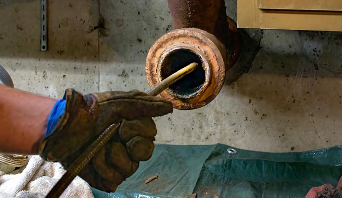 Professional worker repairing a clogged pipe