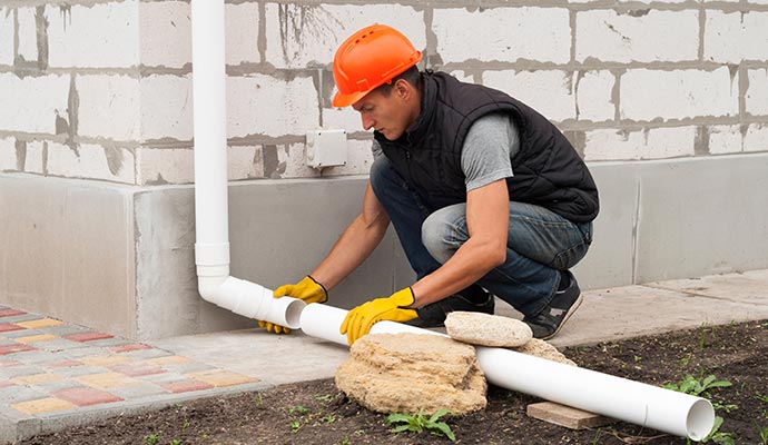 Person installing downspout extension