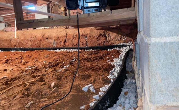 installation of an interior drainage system in a crawl space
