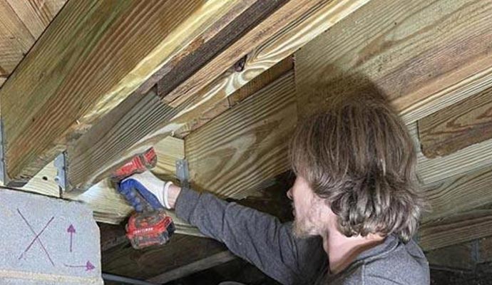A technician repairing a termite-damaged wooden beam